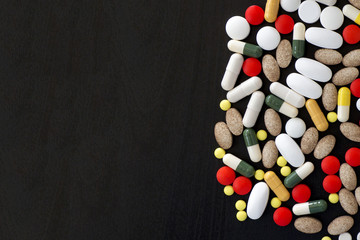 Bunch of various color pills on black background