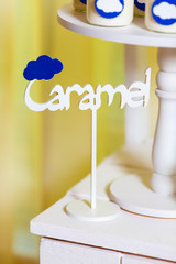 Candy bar on baby's christening party with a lot of different candies and beverages. Decorated in blue colors, clouds theme, indoor