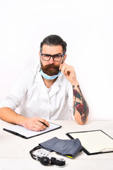 Bearded caucasian doctor sitting at table