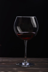 wineglass with wine on black background