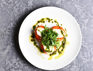 Tasty tomatoes sliced with mozarella cheese and green arugula salad