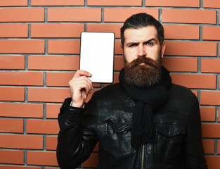 Bearded brutal caucasian hipster holding tablet
