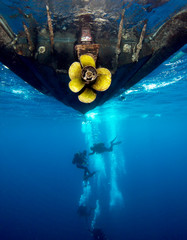 Scuba divers and dive boat from below.