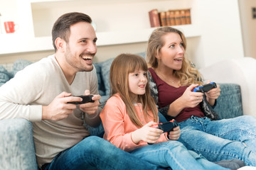Playful family playing video games at home