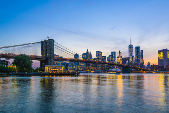 Brooklyn Bridge and Manhattan skyline at dusk, viewed from the East River, New York City