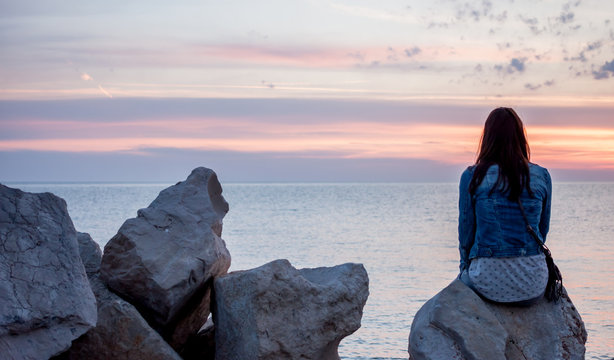 sunset over sea woman looking at horizon
