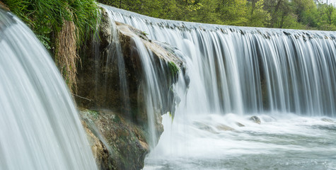 idyllischer Wasserfall in der Natur in der Schweiz im Sommer am Bach panorama
