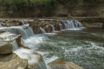 Obraz premium Schöner Wasserfall in idyllischer Natur in der Schweiz im Sommer am Bach