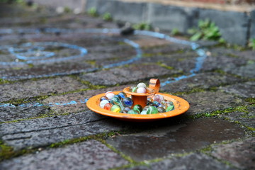 Orange bowl with marbles on the street.