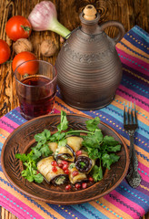 Rolls of fried eggplant with cheese, garlic, cilantro and pomegranate seeds. Gourmet appetizer. Selective focus