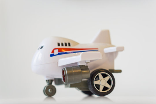 Closeup of white plastic toy airplane on a white table.