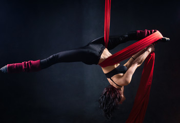 The woman is engaged in aerial acrobatics.