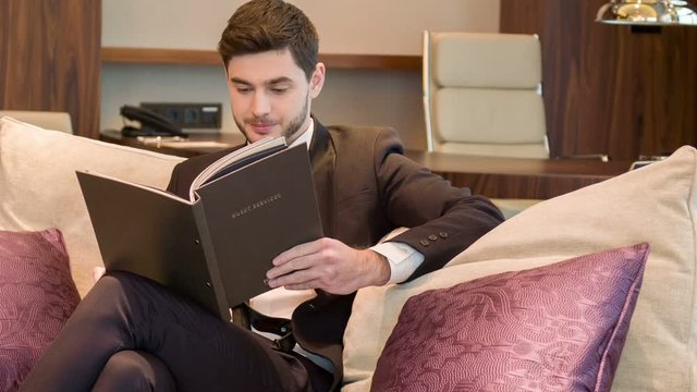 Pleasant businessmna sitting in his hotel room