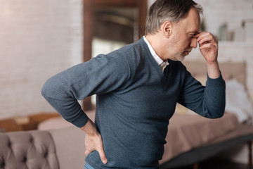 Old man with pain in back and headache