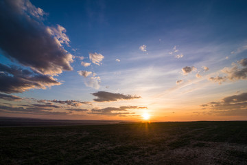 Green field and beautiful sunset. Early spring