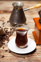 Turkish coffee grinder with beans on the wooden background