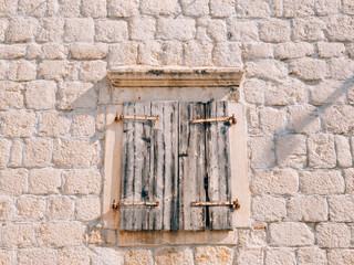 White window shutters. The facade of houses in Montenegro.