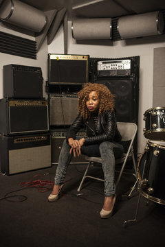 Young woman sitting on chair at recording studio