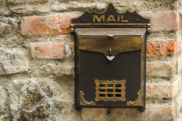 Brown metallic vintage mailbox on a brick wall 