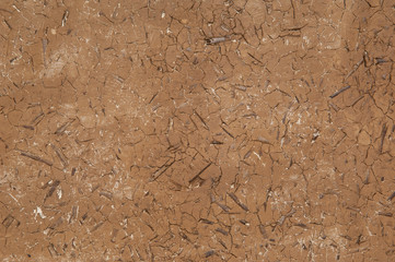 background of dried and cracked clay with wood chips