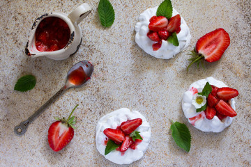 Pavlova meringue pie with fresh strawberries on a background of brown stone.