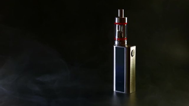Electronic cigarette close-up on a black background in smoke