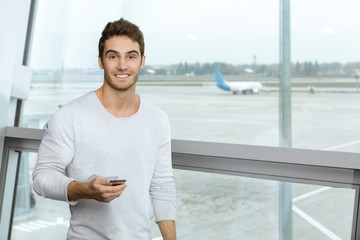 Fototapeta premium Young handsome man at the airport terminal