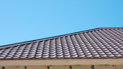 Brown roof of metal roofing on the sky background