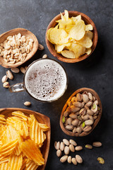 Lager beer and snacks on stone table