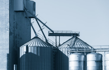 Obraz premium Industrial building with steel tanks, blue toned