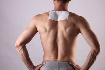 Medicated pain relief patch, plaster. man with back pain. Pain relief and health care concept.