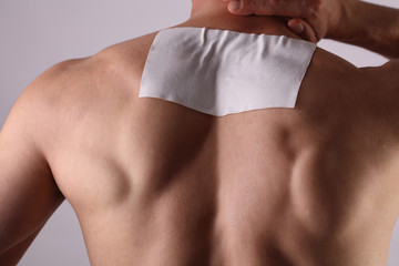 Medicated pain relief patch, plaster. man with back pain. Pain relief and health care concept.