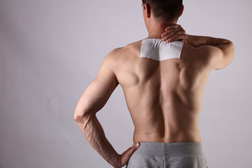 Medicated pain relief patch, plaster. man with back pain. Pain relief and health care concept.