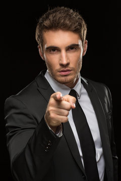 Young man in a suit pointing with his finger