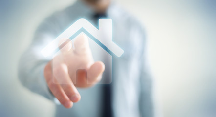 Businessman touching 3D rendering icon house with his finger