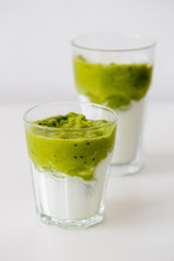 Green vegetarian Smoothie with Antioxidants, granola, kiwi, avocado strawberry for breakfast or lunch on white background. Healthy-woman food concept