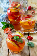 Refreshing summer drink strawberry mojito on a wooden table. The concept of eating vegetarians, fresh vitamins, homemade refreshing fruit drink.
