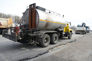Road repair with a big tar machine filling seams. Machines for road repair