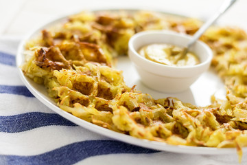 Homemade potato waffles with mustard on striped napkin. Selective focus