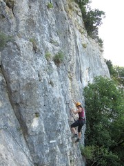 Femme grimpant une falaise sur une via ferrata