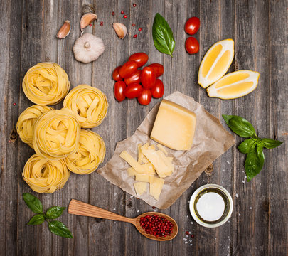 Pasta background frame with ingredients for cooking on weathered wood, top view.