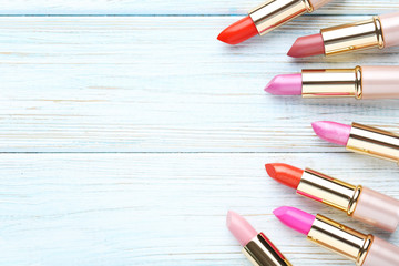 Obraz premium Colorful lipsticks on blue wooden table