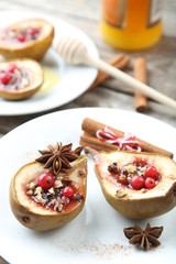 Baked pears with honey, walnuts and cranberries on grey wooden table