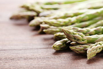 Green asparagus on brown wooden table