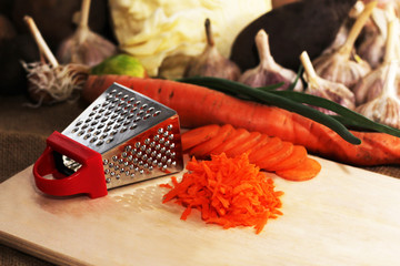 A small metal grater and carrots