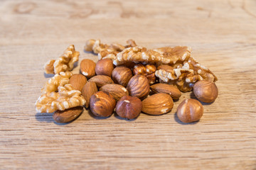 Haselnüsse Mandeln und Walnüsse auf einem Holzbrett
