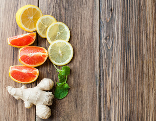 Ginger and lemon, citrus fruits on a wooden background.