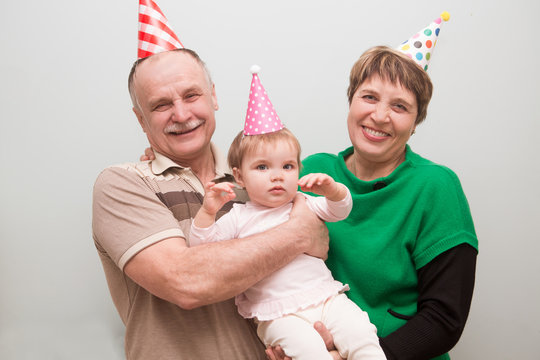 Grandparents With Their Small Grandchild Celebrating First Birthday At Home