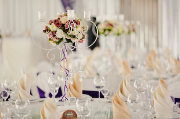 holiday wedding table in white tones with compositions of flowers and candles