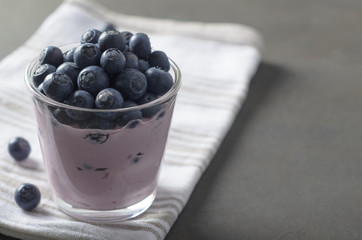 Fototapeta na wymiar Glass of homemade fresh yogurt with blueberries